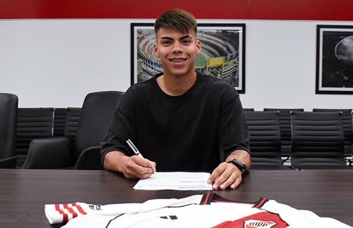 Santiago Espíndola, con lapicera en mano y una gran sonrisa. Prensa River.