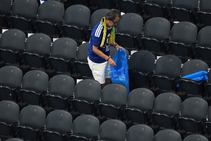 Los hinchas juntando la basura del estadio de Dallas (AP Photo).