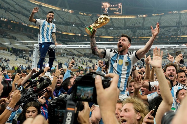 FILE - Argentina's Lionel Messi celebrates with the trophy in front of fans after winning the World Cup final soccer match between Argentina and France at the Lusail Stadium in Lusail, Qatar, Dec. 18, 2022. Argentina won 4-2 in a penalty shootout after the match ended tied 3-3. (AP Photo/Martin Meissner, File)